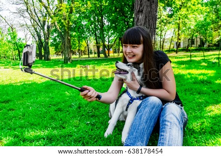 Sitting on grass girl wants to be photographed with her dog