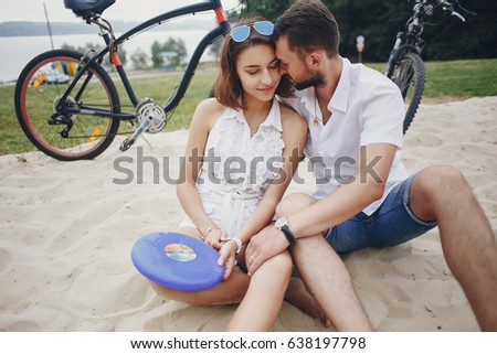 young sport couple walking by the river and uses communication rides a bike
