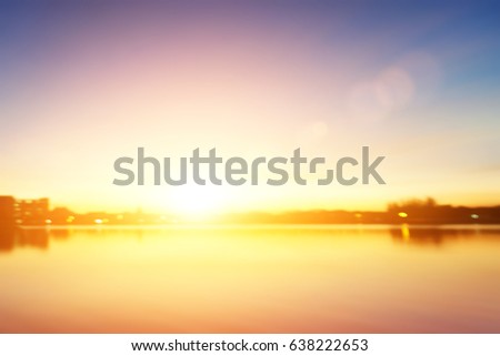 Blurred background of night ctiy has a river and colorful sky sunset.