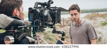 Behind the scene. Actor in front of the camera on the film set outdoor location. Group movie scene Royalty-Free Stock Photo #638227996