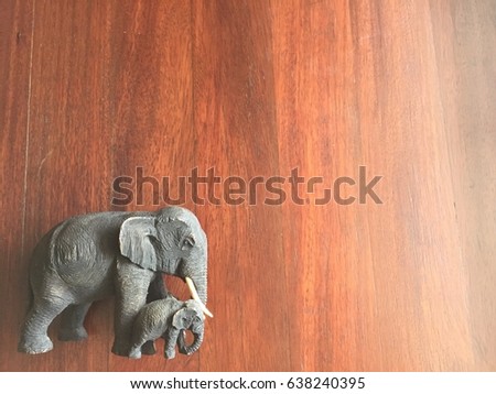 Carved wooden elephants on the wood background.