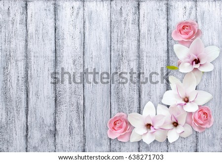 Magnolia flowers with roses on background of shabby wooden planks in rustic style 