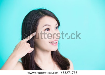 beauty skincare woman point her eye on green background