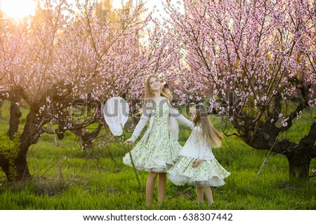 Beautiful sisters in amazing dresses in the gardens