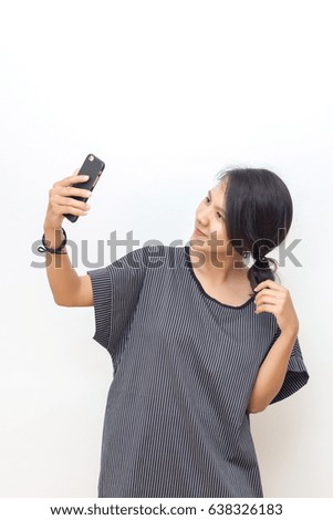 Portrait of a young woman holding a smartphone.Making selfie.