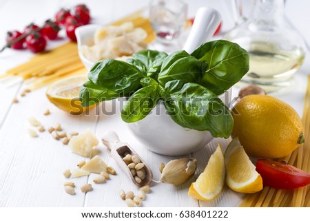 Italian food concept .Various kind of pasta with ingredients sweet basil ,tomato ,garlic ,parsley ,bay leaves ,pepper , and parmesan cheese on white wooden background flat lay.