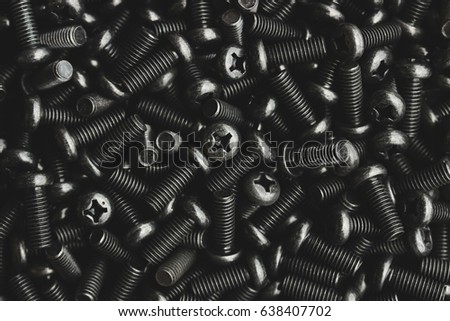 A lot of small metal bolts too scramble on floor by no array, head of bolt have shape like plus symbol and rod have spiral. Photo filter is dark tone style, it present about strength of metal.