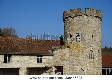 Old medieval stone tower with estate on a blue winter day in France                           