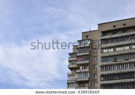 Photo of an old brick multi-storey apartment house in a poorly-developed region of Ukraine or Russia. Obsolete multi-storey building (hostel) against the background of a cloudy sky