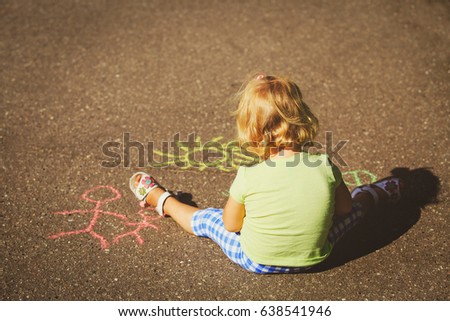 kids play outdoors - little girl drawing family on asphalt