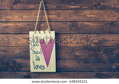 All you need is love - wording with heart on a rustic wooden background with place for text. Happy St. Valentine's, Mother's Day. Love concept. Copy space. Toned image.