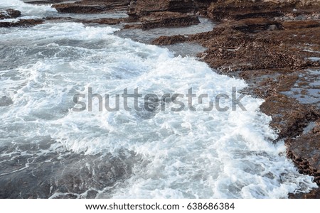 Big waves on the sea with rocks at sunny day. Close up.