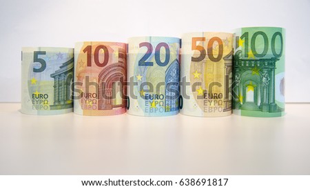 Increasing denominations of rolled Euro notes against a white background, Image of roll of Five Ten Twenty Fifty and hundred euro banknotes, Euro currency money, roll of difference domination notes.