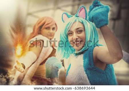 Fantasy world. Disguised cosplay women. Two imaginative characters of the fictional world. A young girl dressed as a cat and another girl with a hand that generates a fire.