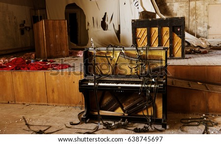 Interior of an abandoned concert hall in provincial cinema. Shabby ruined interior. Broken broken piano with torn pieces of film. Crisis of poor quarter, place of life of homeless beggars