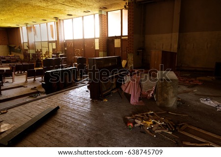 Interior of an abandoned concert hall in provincial cinema. Shabby ruined interior. Broken broken piano with torn pieces of film. Crisis of poor quarter, place of life of homeless beggars