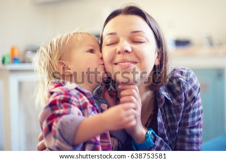 little sweet boy kissing his mom in the room