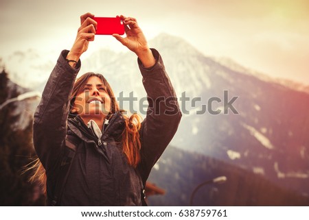 Mountain vacation. Happy woman taking a picture with a cell phone. Vacation in the mountains.