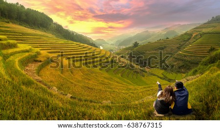  Young couple watching the scenery rice terraces at sunset in Mu cang chai,Yenbai,Vietnam. Royalty-Free Stock Photo #638767315