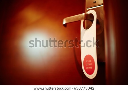 Closeup shot of do not disturb sign hanging on doorknob of hotel room