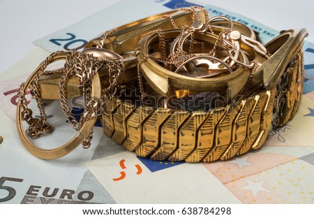A scrap of gold. Old and broken jewelry, watches of gold on a background of Euro banknotes.