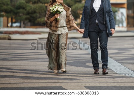A loving couple is walking along the street on the wedding day