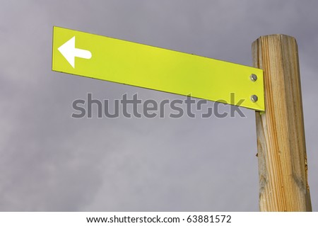 yellow arrow signal against a stormy sky