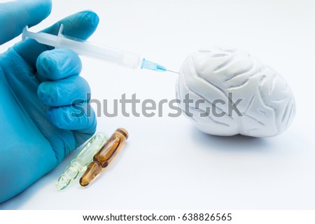 Doctor conducts brain treatment by injecting medication using syringe in 3D model organ. Concept photo symbolizing process of treatment of brain diseases - parkinson's, stroke, tumor, atherosclerosis