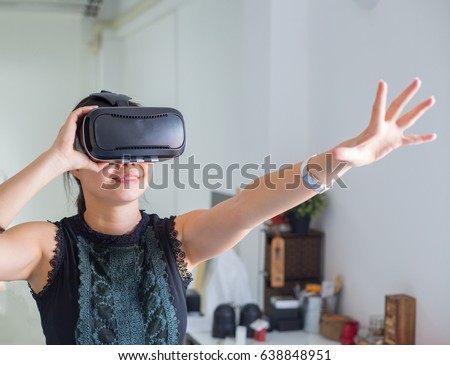 Asian people using VR for watch and play game at home.