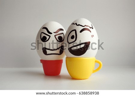 Eggs face. Cheerful company of eggs. Two smiling eggs in mugs with coffee. Photo for your design