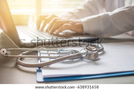 Stethoscope on prescription clipboard and Doctor working an Laptop on desk in hospital, Healthcare and medical concept, vintage color, selective focus Royalty-Free Stock Photo #638931658