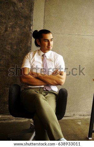 The businesses man sitting in the office waiting for meeting with suppliers.  Handsome model sitting on the office background or relax time
