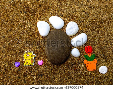 dog  paw made of pebble stone on grain  sand