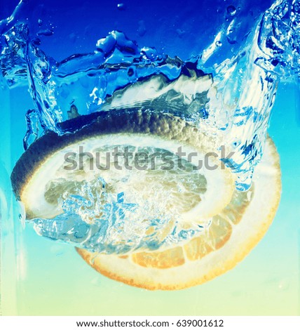 splashing orange fruit in clear water