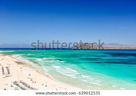 Panorama view of the islands of Lobos and Lanzarote seen from Corralejo Beach (Grandes Playas de Corralejo) on Fuerteventura, Canary Islands, Spain, Europe. Beautiful turquoise water & white sand. Royalty-Free Stock Photo #639012535