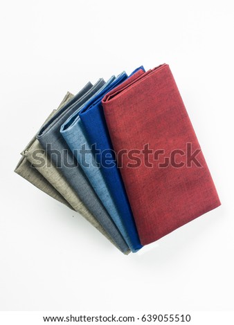 folded colorful fabric textile on white background. Royalty-Free Stock Photo #639055510