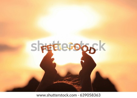 FEEL GOOD text in hands on the sunset sky