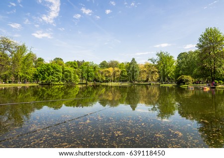 green spring nature with lake sky reflection in city park
