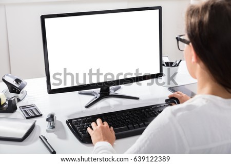 Close-up Of A Businesswoman Using Computer With Blank Screen At Workplace Royalty-Free Stock Photo #639122389