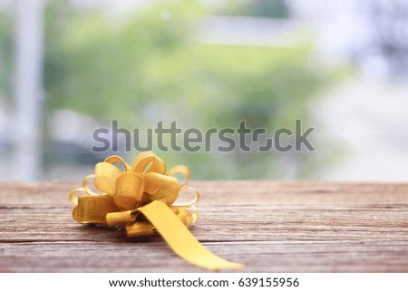 gold gift bow Texture on wooden table on green background
