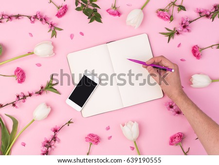 homosexual, beauty blog, spring, summer, concept. male hand with notebook, phone, perfume, sakura, rose, tulips flowers on pink background. flat lay, top view
