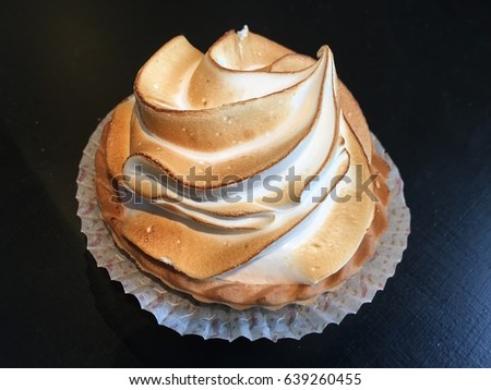 Lemon meringue cake on the black background