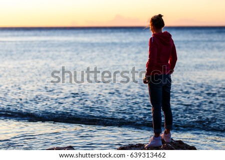 Woman on the seaside at the sunrise
