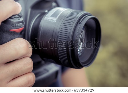 Close up, Yong man asian photographer holding digital camera DSLR with lens equipment for take a photo and picture memories travel landscape trip lifestyle.