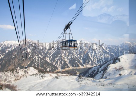 Cable car going to Tateyama Kurobe Alpine Route  on the snow mountains wall , Beautiful landscape the  view  on Tateyama  Japanese Alps with blue sky  background. Toyama city, Japan