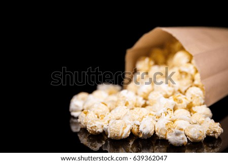 Paper bag with fresh popcorn, black background with copyspace