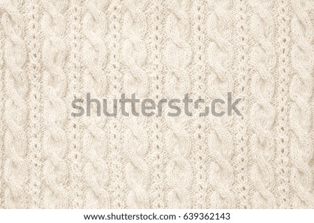 Knitted cloth texture with plaits of neutral colored woolen yarn. 