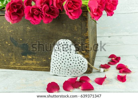 Red roses with a white heart in a wooden box