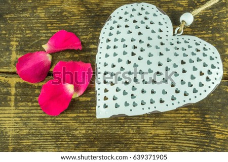 Red roses with a white heart on a rustic wooden table