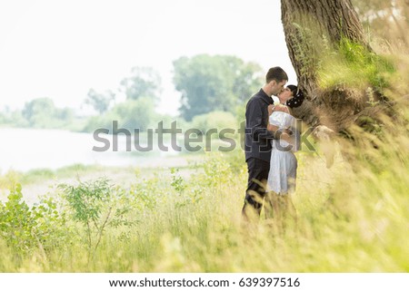 A loving couple at a wedding photo shoot in nature near a large tree root